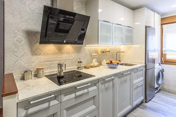 Cocina blanca con campana extractora y placa vitrocerámica